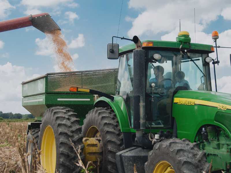 Tractor de una empresa recogiendo grano